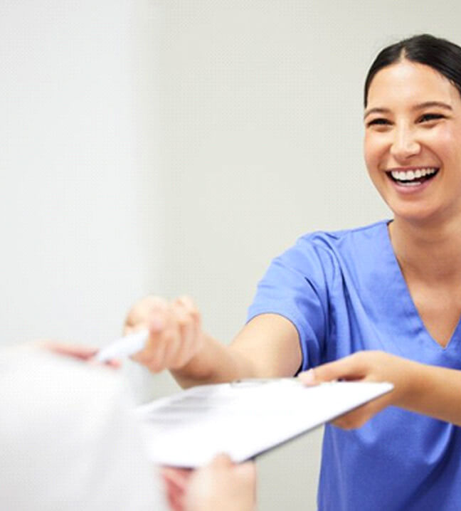 a front desk member handing a patient form