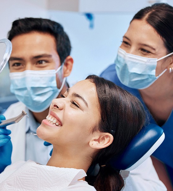 A woman smiling in the mirror at the dentist’s office