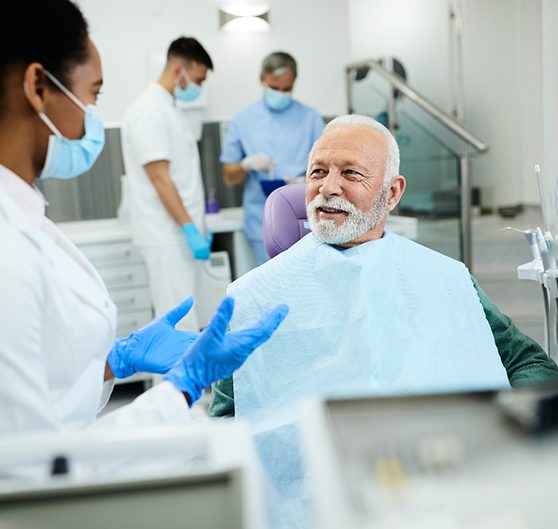 dentist talking to mature woman about dentures in Richardson 