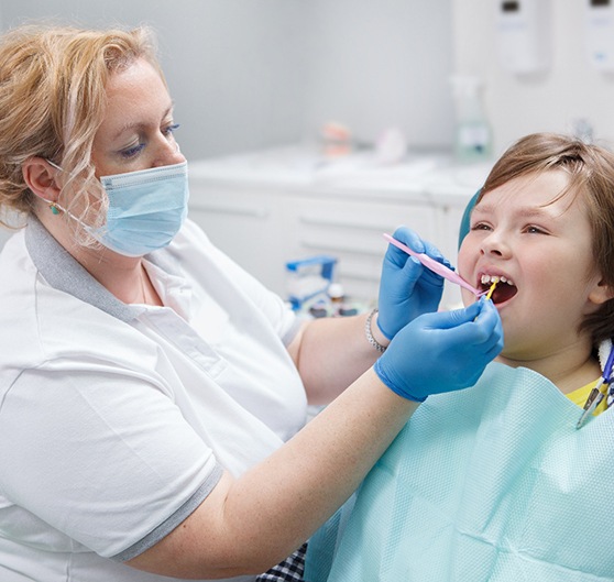 A boy getting fluoride treatment from his dentist