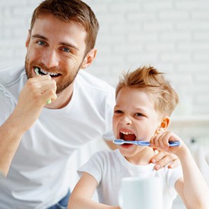 Father and son brushing their teeth