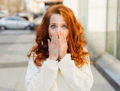 Woman covering her mouth before gum disease treatment