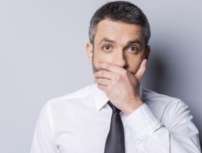 Man covering his mouth before replacing missing teeth