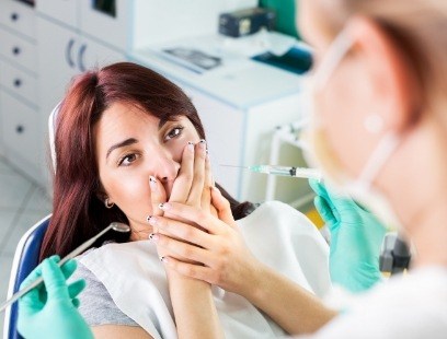 Woman covering her mouth before wisdom tooth extractions
