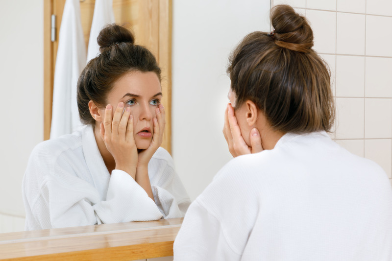 Patient with a toothache rubbing face in mirror